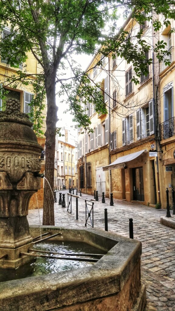 Fountain in a narrow street with cobble stones in Aix-en-Provence