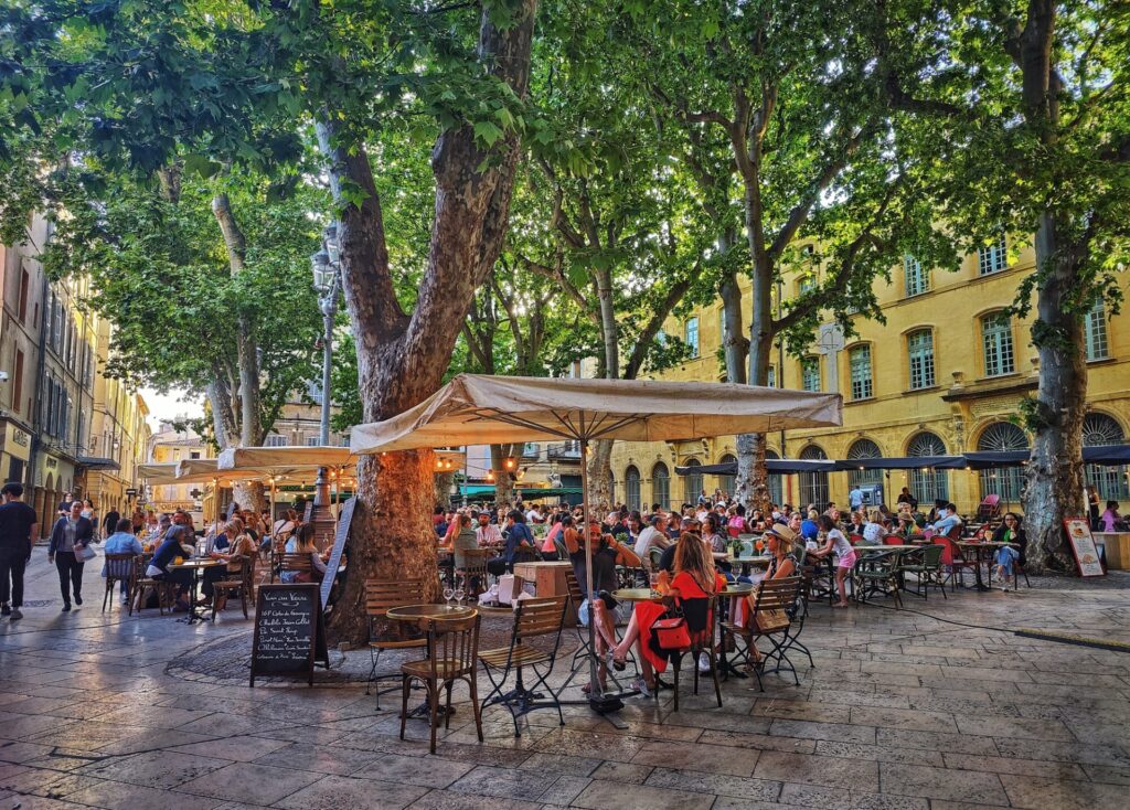 people enjoying the many treed cafes of Place Richelme in Aix-en-Provence