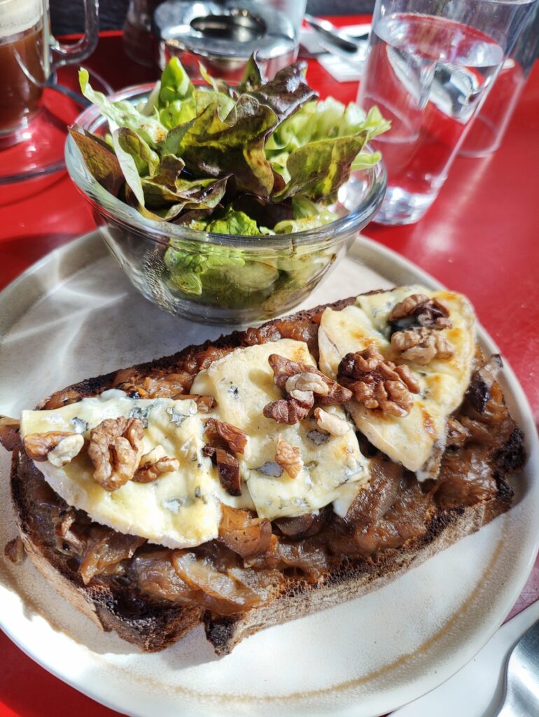 Open face sandwich or tartine at Le Tuyau in Aix topped with cheese, honey and nuts, with a side of green salad