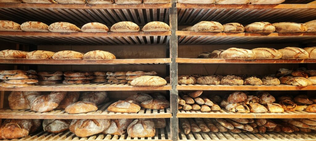 Loaves of bread on wooden shelves at the bakery Farinoman Fou in Aix, south of France