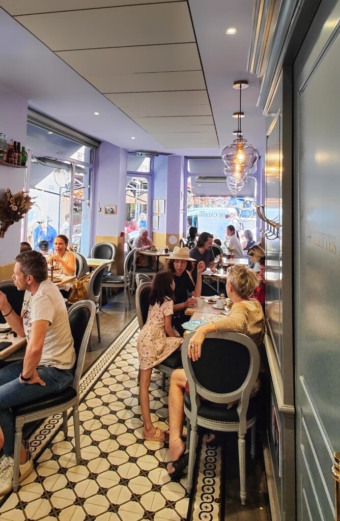 People sitting in a tea room enjoying tea, coffee and desserts.