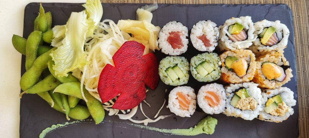 Sushi rolls with a white cabbage salad and a slice of beet root